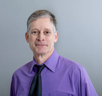 Jim Sacci profile wearing a purple shirt and black tie.